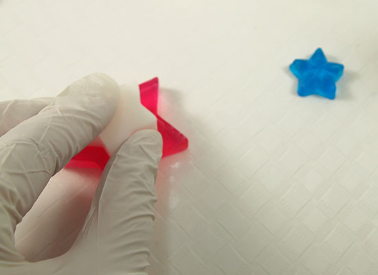 quickly place smaller white star on top of melted soap and press firmly