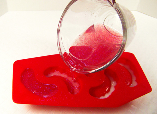 pour pink shimmery soap into soap mold